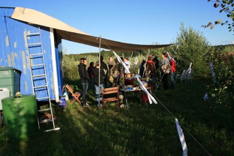 Ankommen bei abendlichem Sonnenschein in unserem Gemeinschaftsgarten: Eine fröhliche Runde von Teilnehmenden trifft sich am Buffet, bevor das Konzert beginnt. Foto: Rudolf H. Ende
