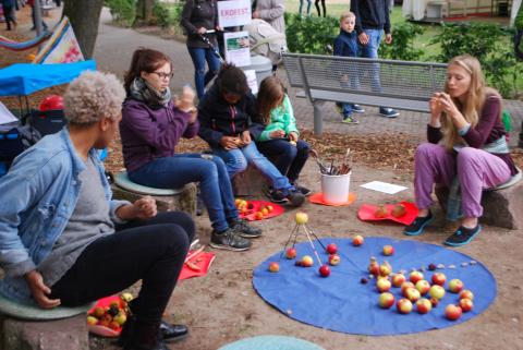 Eine blaue, runde Decke in Anlehnung an unseren Planeten, sortierte Naturhölzer, Erde in Form von Tonklumpen und »natürlich« Äpfel als Mitwirkende. Foto: Kunstschule Lingen